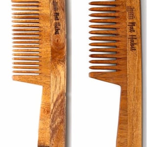 Peut inclure: Deux peignes en bois, l'un à dents larges et l'autre à dents fines, sont présentés sur fond blanc. Ils sont en bois brun clair et ont un manche. Le texte "Nat Habit" est imprimé sur le dessus de chaque peigne.