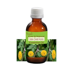 May include: A brown glass bottle with a white cap, labelled "Bangolo Pure & Natural Cassie (Sweet Acacia) Essential Oil". The bottle is sitting on a green background with yellow flowers.