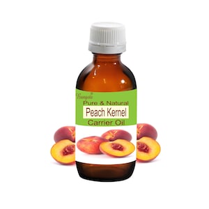 May include: A brown glass bottle with a white cap, labeled "Pure & Natural Peach Kernel Carrier Oil" with a green background and a peach design. The bottle is surrounded by four peach halves.