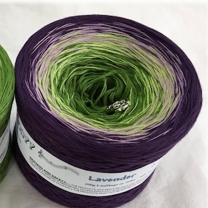 May include: A skein of purple, green and pink ombre yarn with the label "Lavender 200g Lauflange ca 700m 100% Baumwolle" on the side.