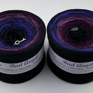 May include: Two skeins of black yarn with a gradient of purple, blue, and pink. The yarn is labeled "Bad Angel" and has a 200g length of approximately 780m. The yarn is 50% cotton and 50% acrylic.