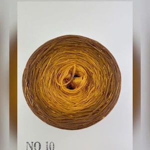 May include: A skein of gold yarn with a brown center, labeled "NO 10".