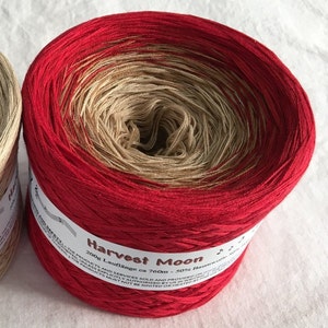 May include: A skein of red and beige yarn labeled "Harvest Moon" with the text "200g Lauflange ca 760m - 50% Baumwolle"