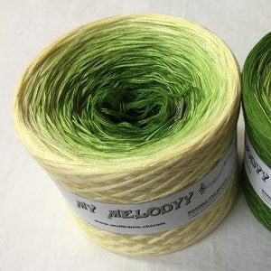 May include: A skein of yellow and green ombre yarn with the label "My Melody" and the website "www.wolltraum.ch/com".