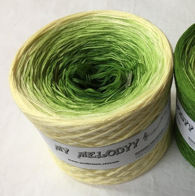 May include: A skein of yellow and green ombre yarn with the label "My Melody" and the website "www.wolltraum.ch/com".