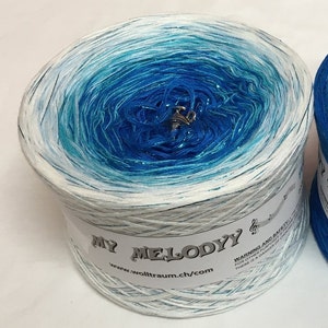 May include: A skein of blue and white yarn with glitter, labeled "My Melody" and "www.wolltraum.ch/com".