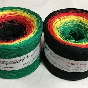 May include: Two skeins of yarn in a multi-colored pattern of green, yellow, red, and black. The yarn is labeled "My Melody" and "One Love".