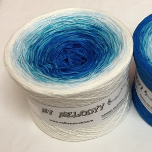 May include: A skein of white yarn with a blue and turquoise ombre effect. The yarn is wound into a ball and has a label that reads "My Melody" and "www.wolltraum.ch/com".