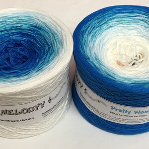 May include: Two skeins of yarn in a gradient colorway of white to blue. The skein on the left is labeled "My Melody" and the skein on the right is labeled "Pretty Women".