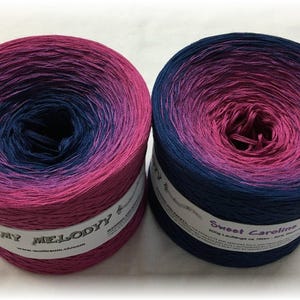 May include: Two skeins of ombre yarn, one in shades of pink and blue labeled "My Melody" and the other in shades of pink and blue labeled "Sweet Caroline".