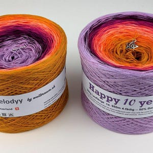 May include: Two colorful yarn cakes. One is orange, purple, and yellow, labeled "My Melodyy." The other is purple, orange, and pink, labeled "Happy 10 years 1." Both have a silver charm.