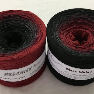 May include: Two skeins of yarn, one red and black ombre and one black and red ombre. The yarn is labeled "My Melody" and "Black Widow".
