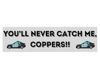 Op de afbeelding: Een zwart-witte bumper sticker met de tekst "YOU'LL NEVER CATCH ME, COPPERS!!" en twee cartoon politieauto's aan weerszijden.