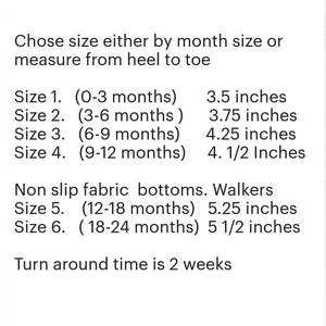 May include: Text on a white background provides sizing information for baby shoes. Sizes are listed by age in months and corresponding measurements in inches, ranging from 3.5 to 5.5 inches. The text also mentions non-slip fabric bottoms.