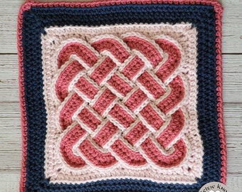 Pode incluir: Uma peça quadrada de crochê feita à mão com um design de nó celta. O nó é um padrão tecido em tons de rosa e branco, sobre um fundo rosa claro. Uma borda azul marinho emoldura o design, com uma borda rosa. O texto "Celtic Knot Crochet" está no canto inferior direito.