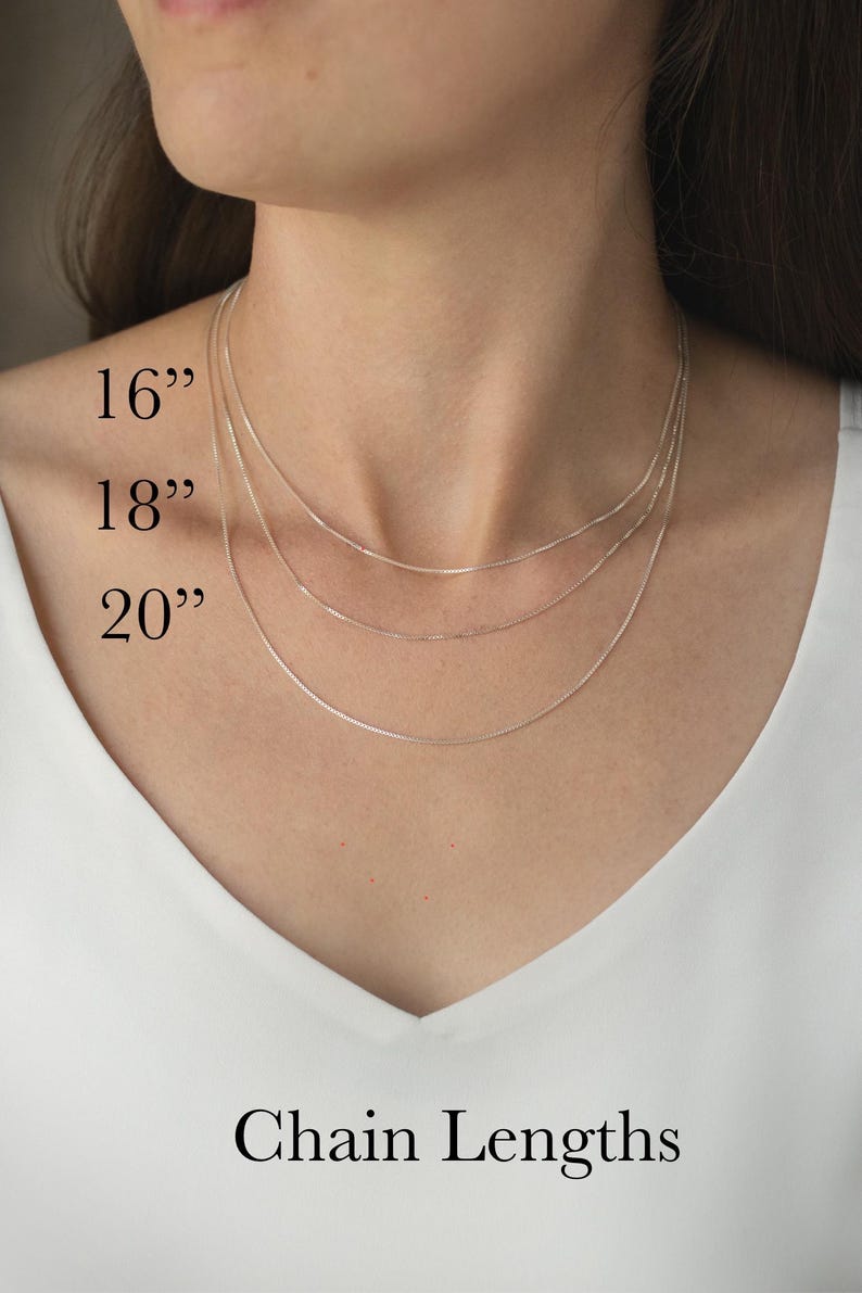 May include: A close-up of three silver chain necklaces of varying lengths: 16", 18", and 20". The text "Chain Lengths" is displayed below the necklaces. The chains are shown against a white background.
