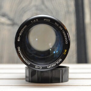 May include: A black and silver 80-200mm zoom macro lens with a 55mm filter thread. The lens is labeled "Soligor" and "MC" and has a serial number of "No. 381862200".