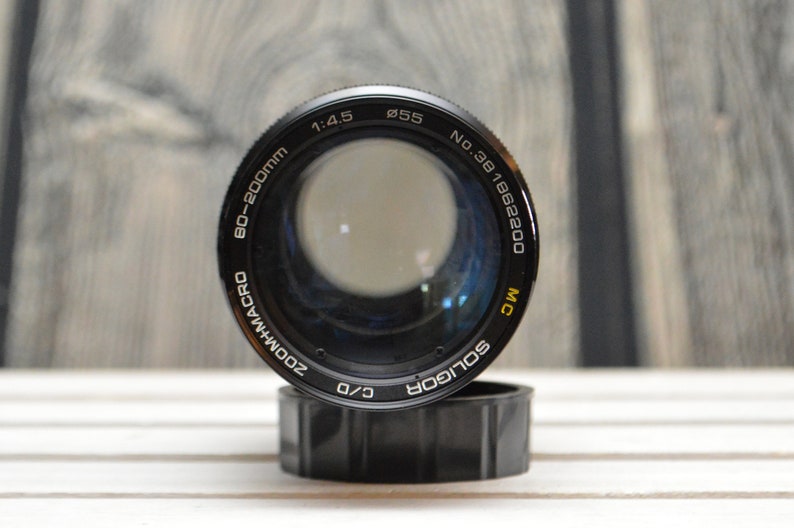 May include: A black and silver 80-200mm zoom macro lens with a 55mm filter thread. The lens is labeled "Soligor" and "MC" and has a serial number of "No. 381862200".