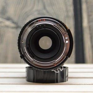 May include: Close-up of a black camera lens with a silver ring and the text "N/A1" printed on it.