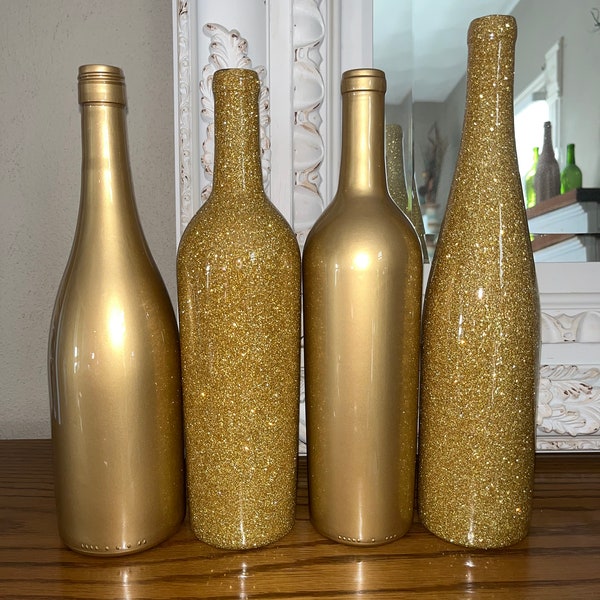 Centros de mesa con botellas de vino doradas