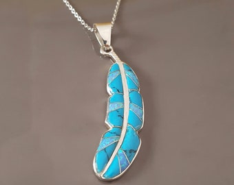 May include: A silver pendant shaped like a feather, inlaid with bright turquoise and iridescent blue opal segments. The pendant hangs from a delicate silver chain, featuring a central silver spine that divides the colorful stone inlays.