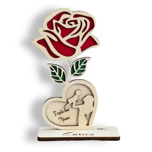 Può includere: Sagoma in legno di una rosa rossa con foglie verdi, un cuore con una madre e un bambino al suo interno, e il testo "Ti voglio bene Mamma" e "Enrico" alla base.