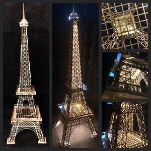 May include: A wooden Eiffel Tower model with intricate lattice detailing. The model is illuminated from within, showcasing the architectural design. The image includes multiple views of the tower, highlighting its structure and lighting.