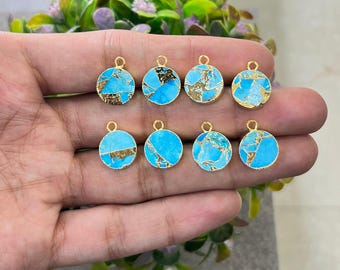May include: Eight round turquoise and gold-colored pendants with a small loop at the top for stringing. The pendants have a gold-colored border and a gold-colored vein pattern running through the turquoise. The pendants are displayed against a blurred green background.