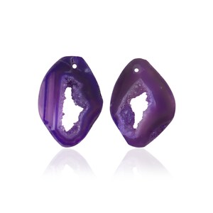 May include: Two purple agate gemstone earrings with a natural crystal druzy pattern and a hole for hanging.