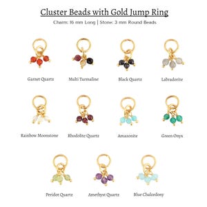 Könnte beinhalten: Eine Sammlung goldfarbener Cluster-Bead-Anhänger mit Sprungringen. Jeder Anhänger hat eine Ansammlung kleiner, runder Edelsteine in verschiedenen Farben, darunter Rot, Schwarz und Grün. Der Text lautet "Cluster Beads with Gold Jump Ring" und "Charm: 16 mm Long | Stone: 3 mm Round Beads."