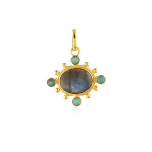 May include: A gold-colored pendant with an oval, gray-blue stone at the center, surrounded by small, round, light green stones. The pendant has a loop at the top for hanging.