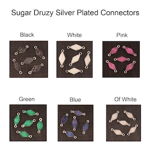 Puede incluir: Seis conectores plateados con forma de diamante y acabado druzy en seis colores diferentes: negro, blanco, rosa, verde, azul y blanco roto.