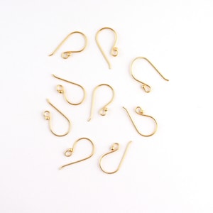 Puede incluir: Ocho ganchos para pendientes de oro con una pequeña bola en el extremo de cada gancho.