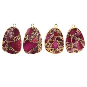 Może przedstawiać: Cztery złote zawieszki z marmurowym wzorem w kolorze różowym i złotym. Każda zawieszka ma kształt łzy i ma pętelkę u góry do przymocowania łańcuszka.