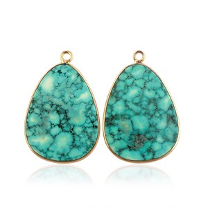 May include: A pair of turquoise gemstone teardrop pendants with gold-toned metal settings. The turquoise is a mottled green and blue color.