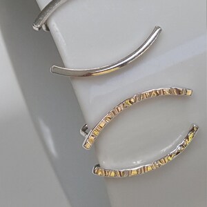 Puede incluir: Tres pendientes de aro de plata, dos son lisos y uno tiene un dise&ntilde;o texturizado.