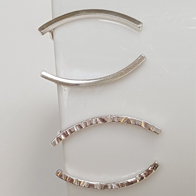 Puede incluir: Cuatro pendientes de aro de plata, dos son lisos y dos tienen una superficie texturizada.