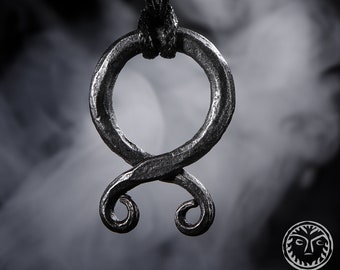 May include: A silver pendant necklace with a stylized knot design. The pendant is on a black cord.