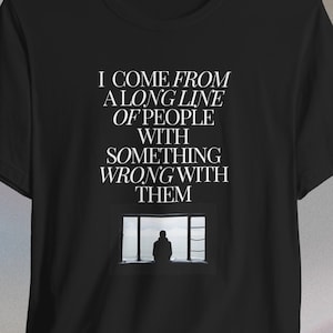 May include: Black t-shirt with white text that reads "I come from a long line of people with something wrong with them". A silhouette of a person is in a window frame.