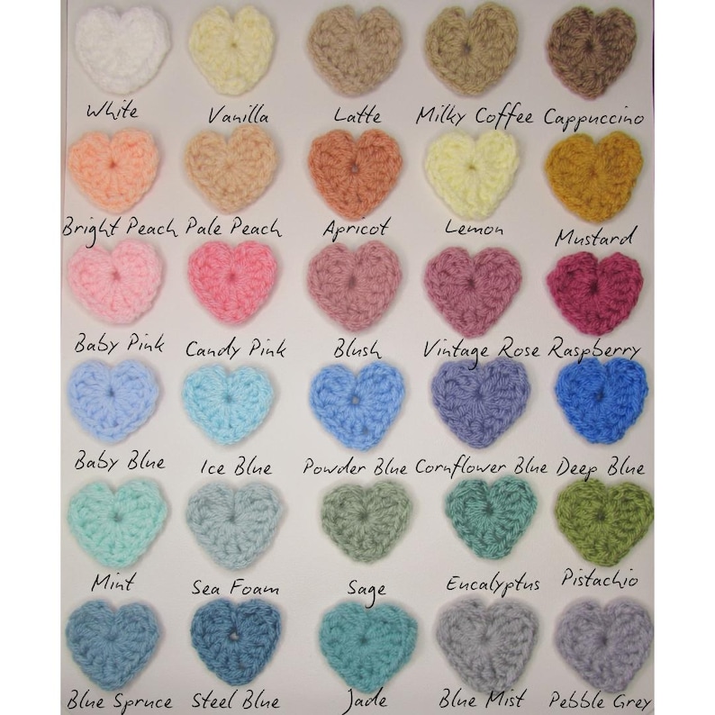 May include: A collection of crochet heart shapes in various colors, including white, pink, blue, and green. Each heart is labeled with its color name, such as "White," "Baby Pink," and "Mint." The image showcases a range of hues and shades.