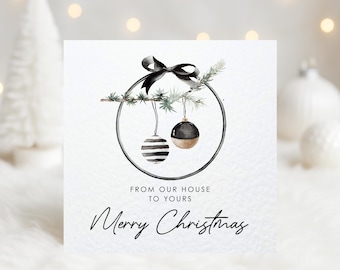May include: A square Christmas card with a watercolor design. The card features a black bow, a circular frame with two ornaments, and the text "From our house to yours" and "Merry Christmas". The ornaments are black and gold.
