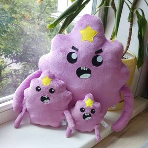 May include: Three plush toys shaped like a purple creature with a yellow star on its head. The largest plush toy has a grumpy expression, the medium plush toy has a surprised expression, and the smallest plush toy has a scared expression.