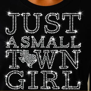Puede incluir: Camiseta negra con la frase "JUST A SMALL TOWN GIRL" en brillantes pedrería. El diseño incluye un contorno de pedrería del estado de Texas. Archivo digital disponible en formatos SVG, PNG y DXF.