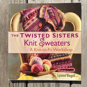 May include: A book titled "The Twisted Sisters Knit Sweaters" with a knit sweater draped over a chair. The book cover features a knit sweater and yarn balls. The book is a "Knit-to-Fit Workshop".
