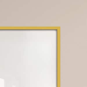 May include: A corner view of a rectangular picture frame with a bright yellow border. The frame surrounds a white interior, set against a neutral beige background. The frame's clean lines and bold color create a modern aesthetic.