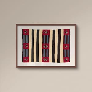 May include: Framed textile art featuring a woven design with vertical stripes in black, cream, and red. The red sections have cross-like patterns and blue stripes. The artwork is displayed in a brown frame.