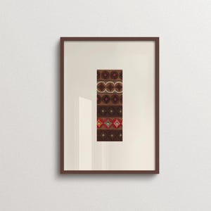 May include: A framed vertical artwork featuring a central rectangular panel with repeating geometric patterns in shades of brown, tan, and red. The design consists of stacked rows of circles and diamonds, enclosed in a simple dark brown wooden frame.