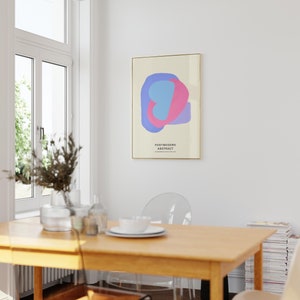 Peut inclure: Une affiche minimaliste avec un design abstrait bleu clair et rose. L'affiche est encadr&eacute;e d'or et porte le texte "POSTMODERN ABSTRACT" imprim&eacute; dessus.