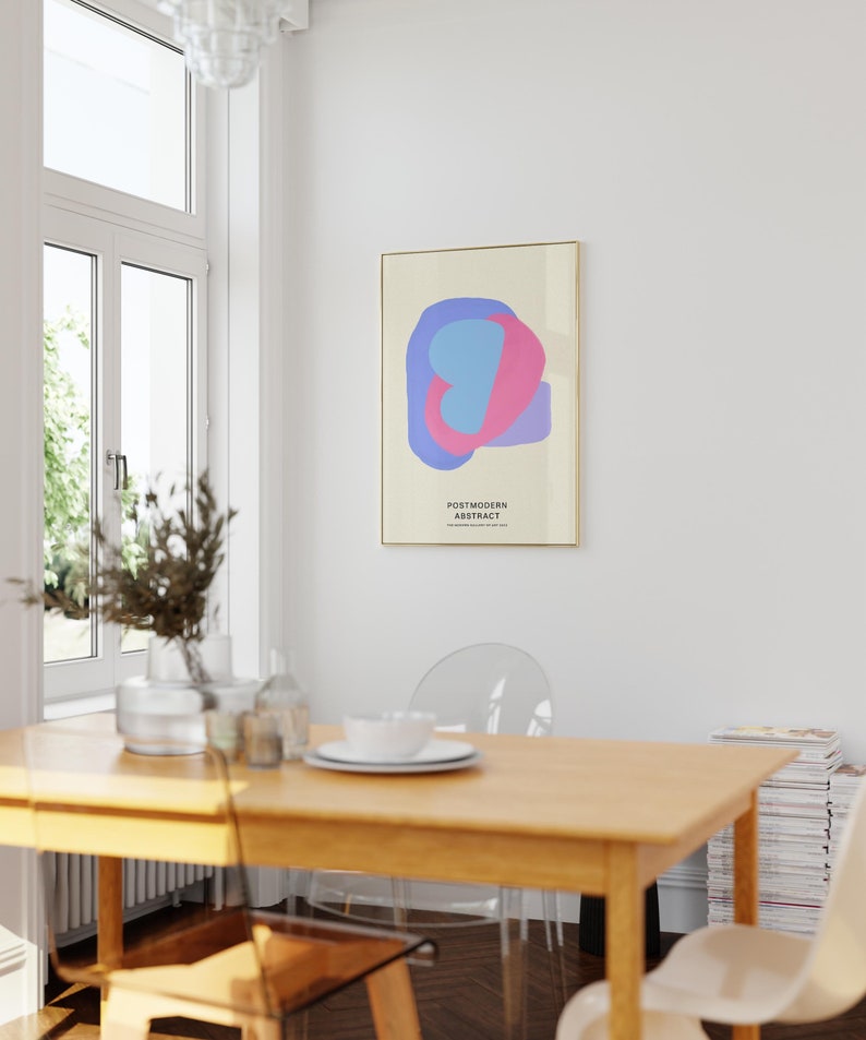 Peut inclure: Une affiche minimaliste avec un design abstrait bleu clair et rose. L'affiche est encadr&eacute;e d'or et porte le texte "POSTMODERN ABSTRACT" imprim&eacute; dessus.