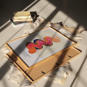 May include: A framed abstract art print with a colorful, swirling design in shades of orange, pink, blue, and green. The print is titled "082217 / INSTRUCT LIQUID FORM 1 VERSION" and is by Emil du Sv&eacute;risson.